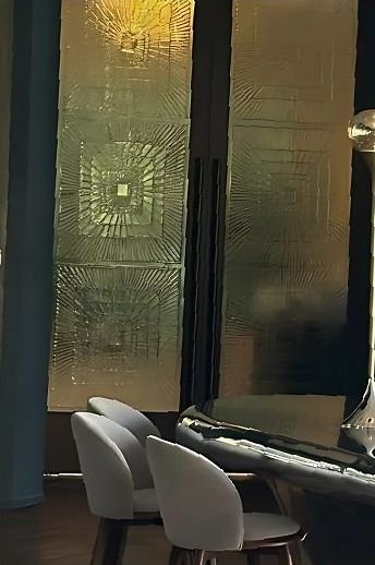 Antique brass etched wall panel beside restaurant seating