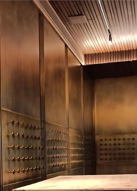 Antique brass wall cladding with studded detailing