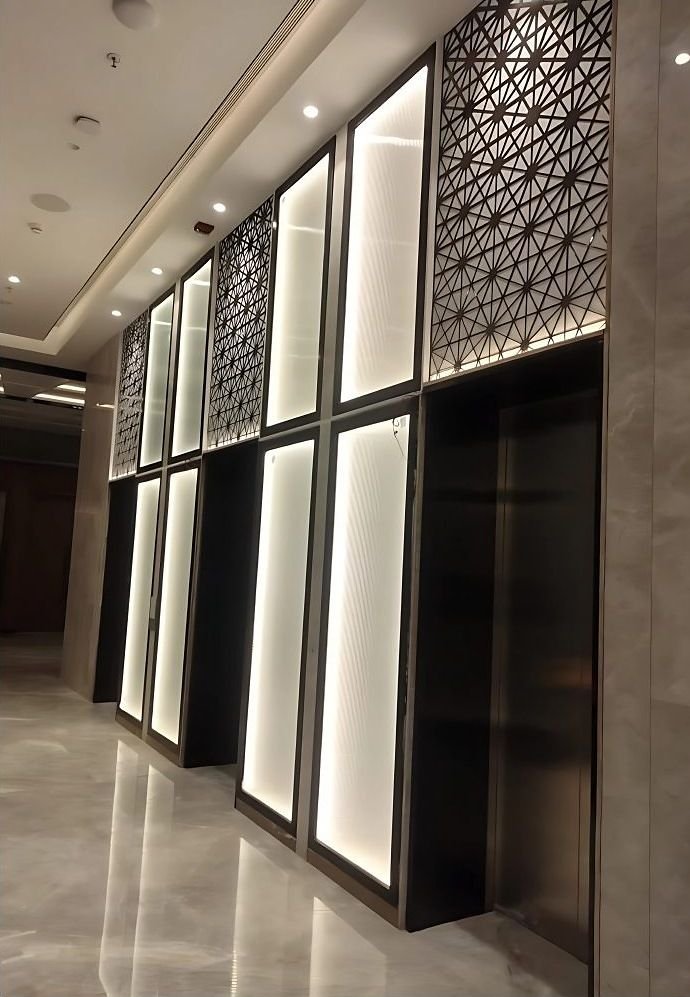 Backlit metal screen panels lining a corridor