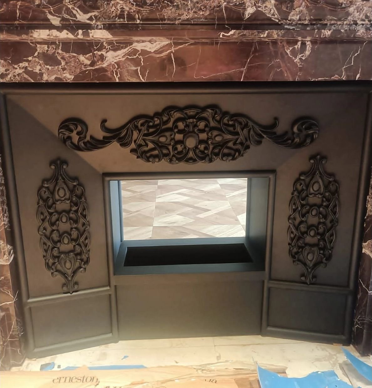 Ornate blackened metal fireplace surround