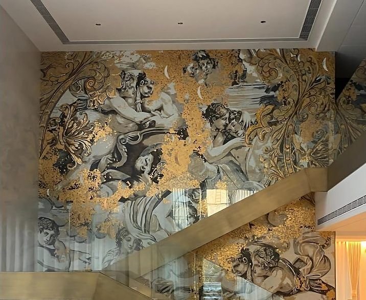 Brass balustrade beside a gold mural staircase