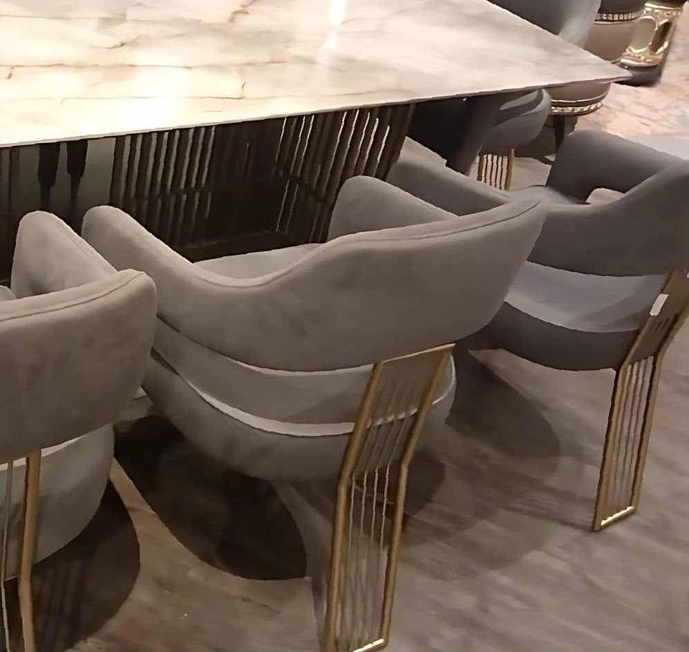 Brass-framed dining chairs around a marble table