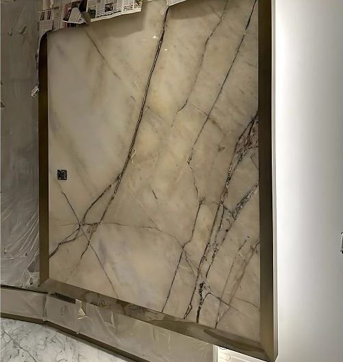 Brass frame around a book-matched marble feature wall