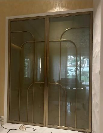 Brass-framed glass doors with arched glazing bars