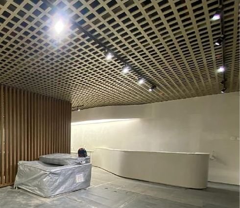 Brass open-cell ceiling grid over a reception area