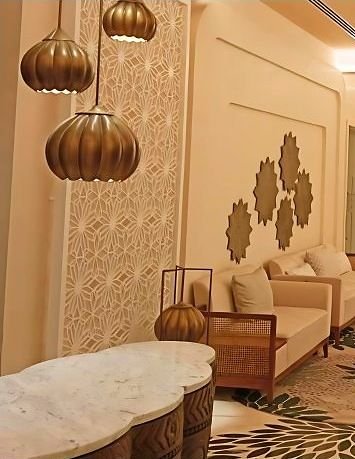 Brass perforated screens framing a hotel lounge seating area