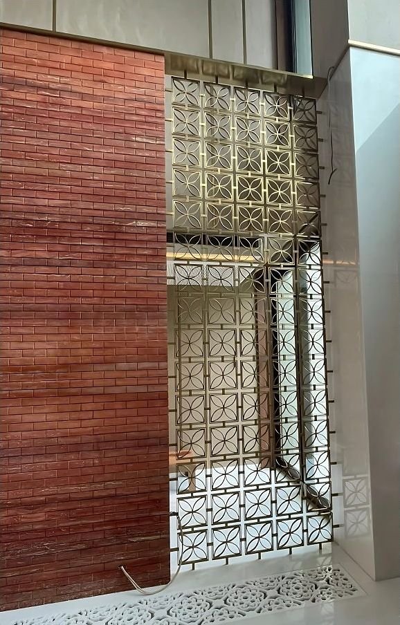 Brass screen over a window in a brick facade