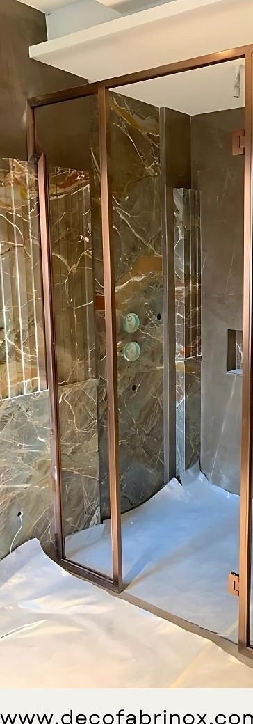 Brass shower partition set into a marble bathroom