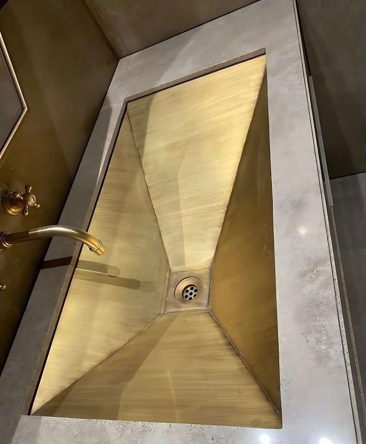 Hand-formed brass shower tray with a folded surround