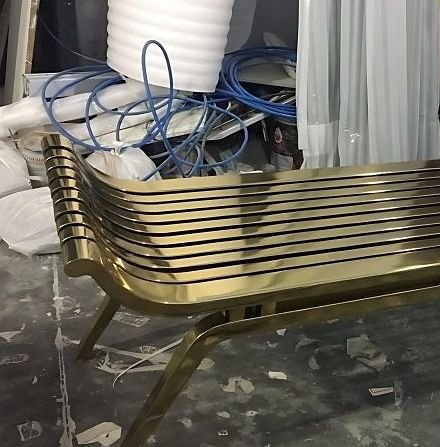 Brass slatted bench in the finishing area of the workshop