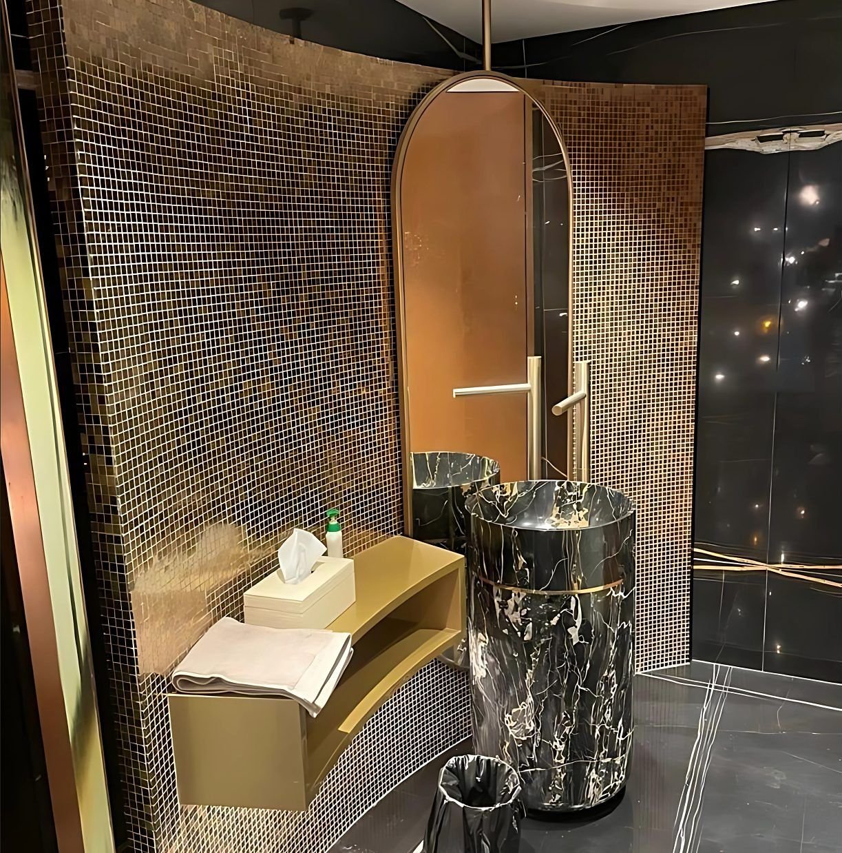 Brass vanity counter in a mosaic-tiled bathroom