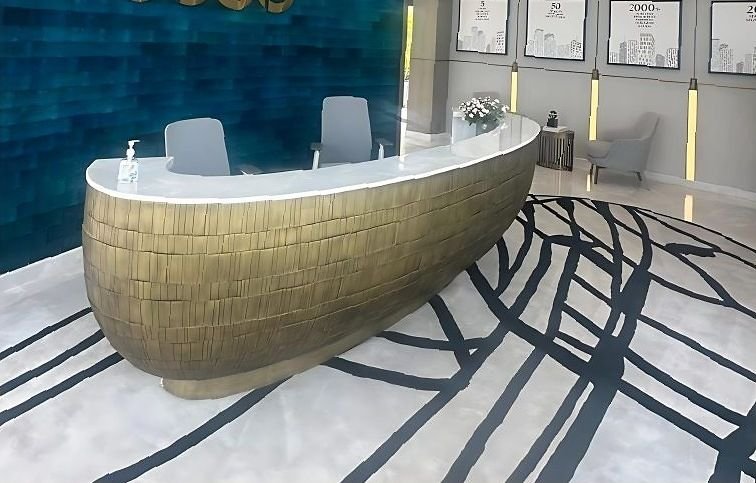 Woven brass reception desk curving across a corporate lobby floor