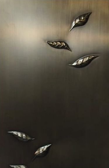 Bronze leaf inlays set into a dark metal panel