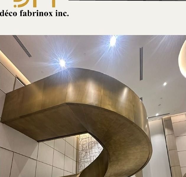 Brushed brass balustrade wrapping a curved flight of stairs