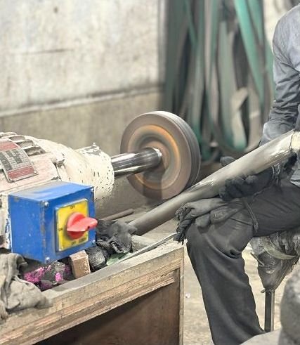 Buffing a metal tube in the workshop