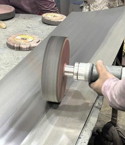 Buffing wheel polishing a metal surface by hand