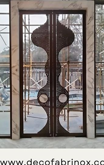 Copper laser-cut entrance door under installation