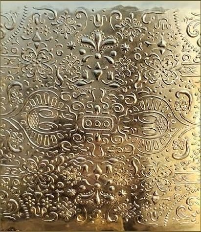 Embossed brass panel with an ornamental pattern