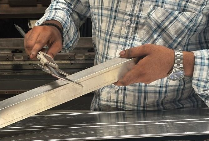 A craftsman hand-deburring a metal profile