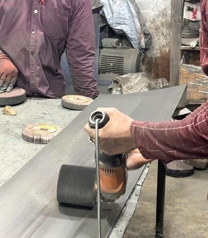 Hand-grinding a large metal sheet