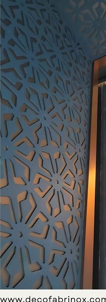 Blue laser-cut metal screen panel set against a wall
