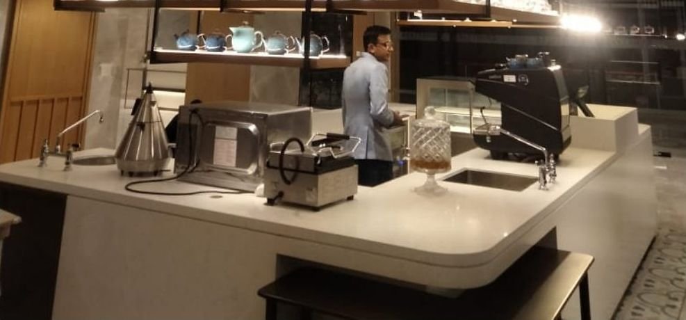 Barista counter beneath a slim metal canopy structure