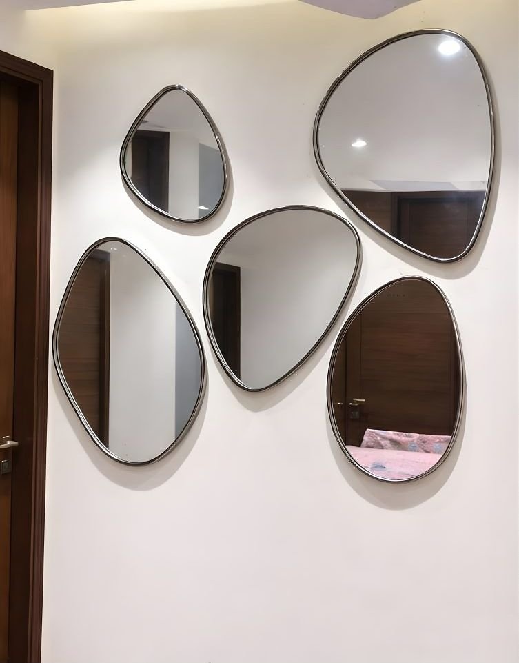 Cluster of pebble-shaped metal-framed mirrors on a wall