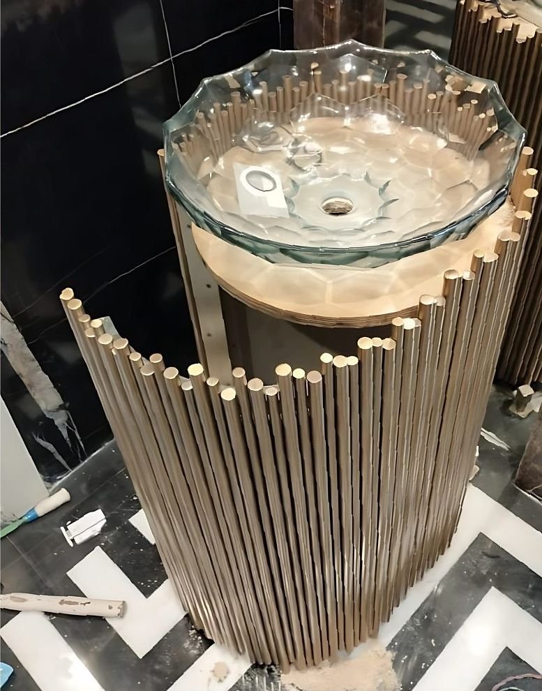 Metal rod pedestal supporting a glass vanity basin