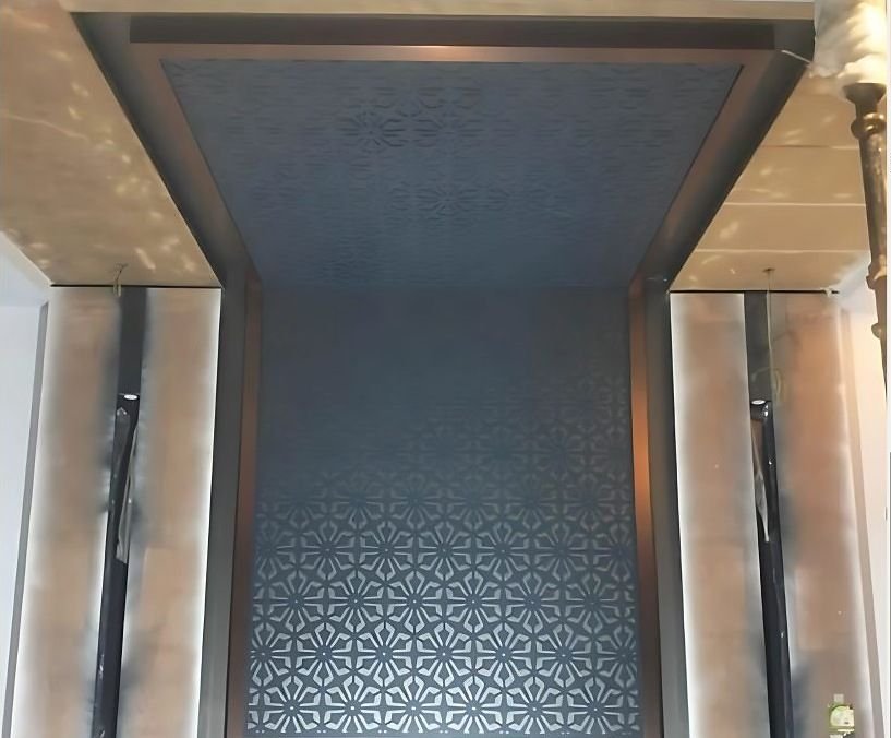 Patterned metal ceiling above a lift lobby