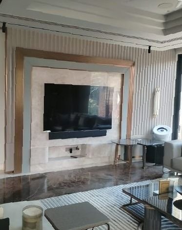 Rose gold framed media wall above a marble console