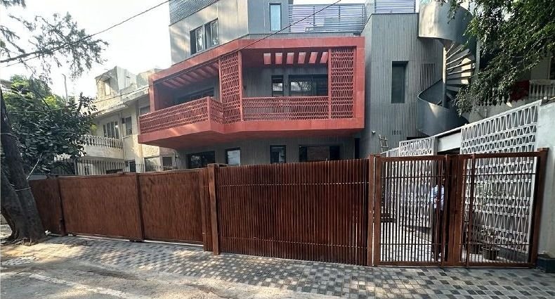 Slatted metal boundary gate and fencing outside a residence