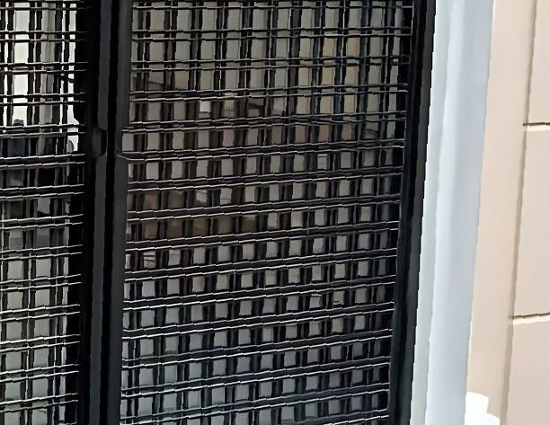 Detail of a blackened steel grid facade screen