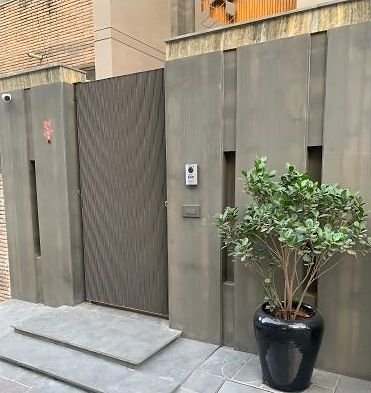 Textured metal gate set into a boundary wall