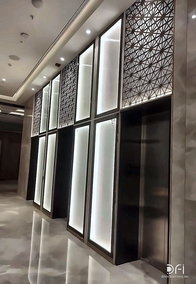 Backlit metal screen panels lining a corridor
