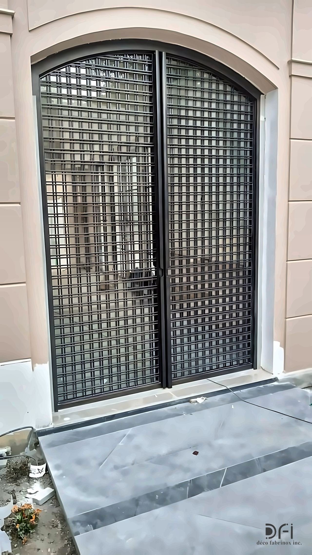Arched black metal grille entrance door