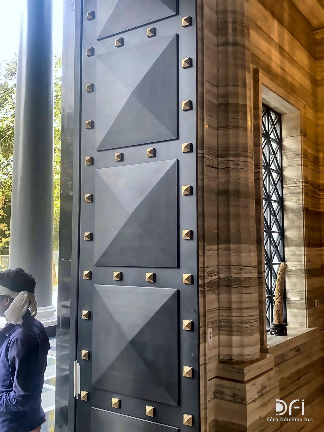 Studded faceted dark metal door panel