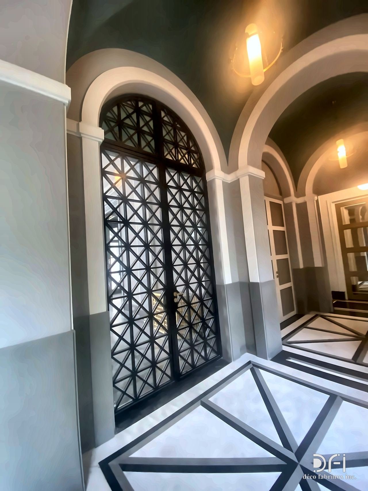 Arched black metal lattice door in an archway