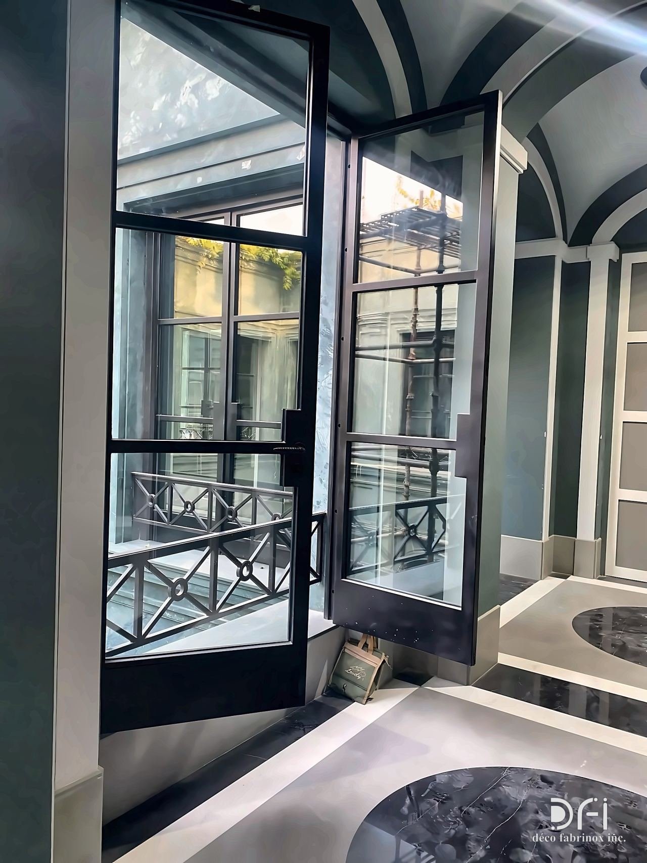 Black steel-framed glass doors opening to a balcony