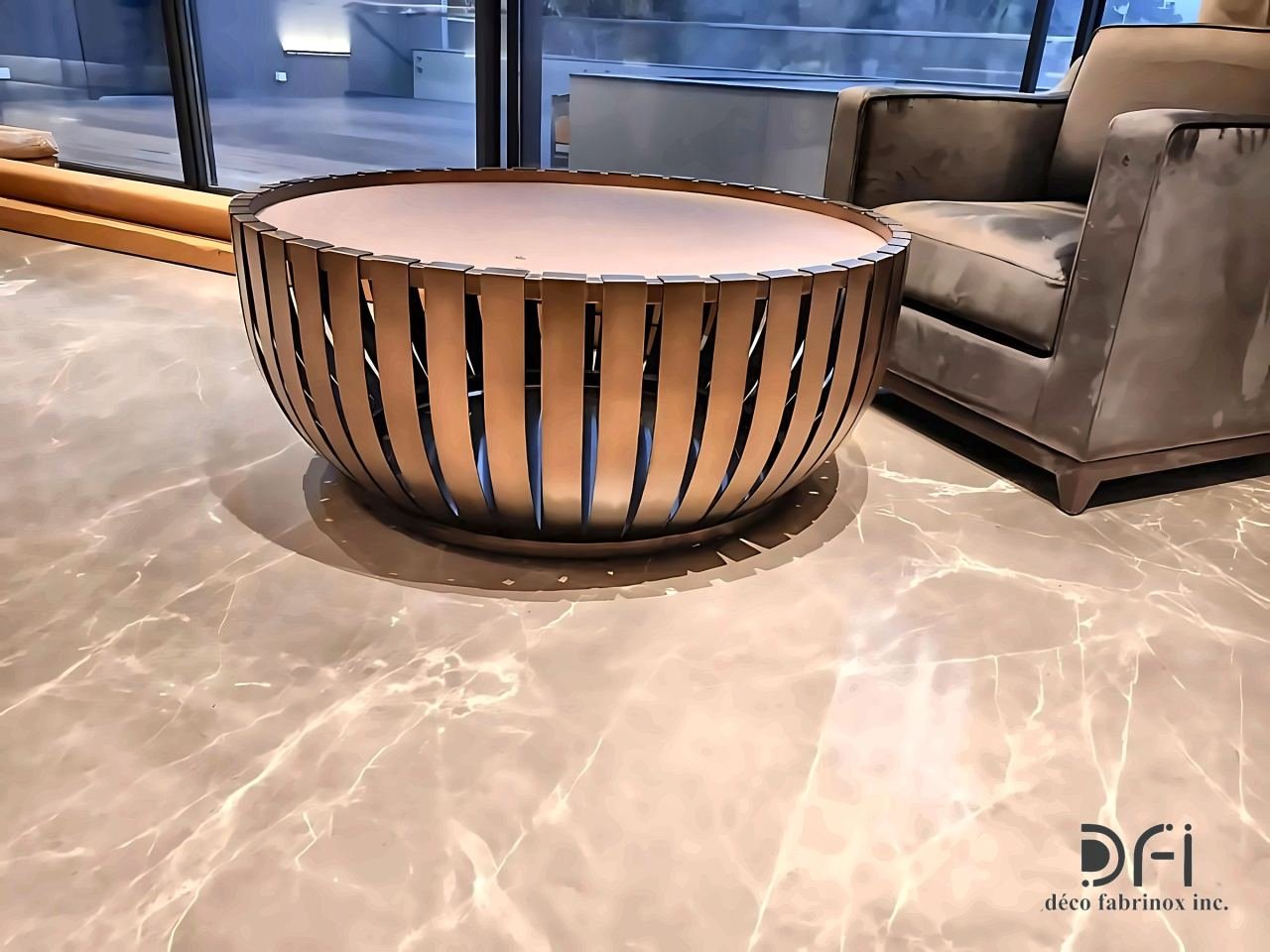 Round table base of bronze fins beside an armchair