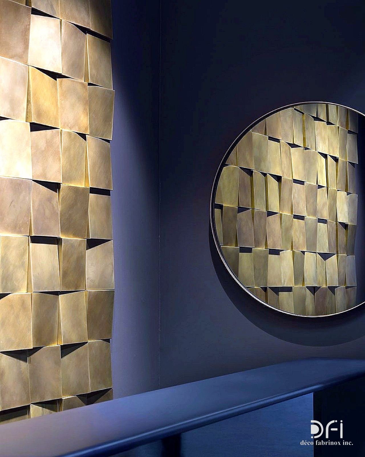 Brass 3D tile wall with a round framed mirror