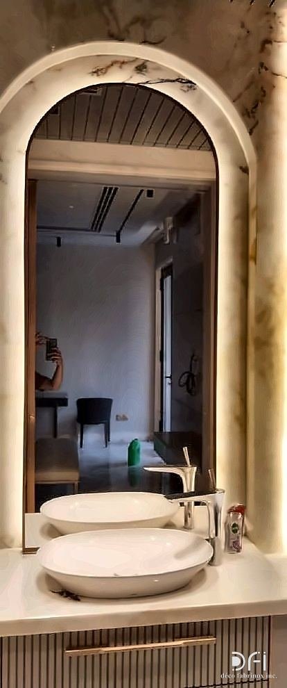Brass arched mirror above a fluted vanity