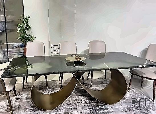 Dining table on a sculpted brass base with a glass top