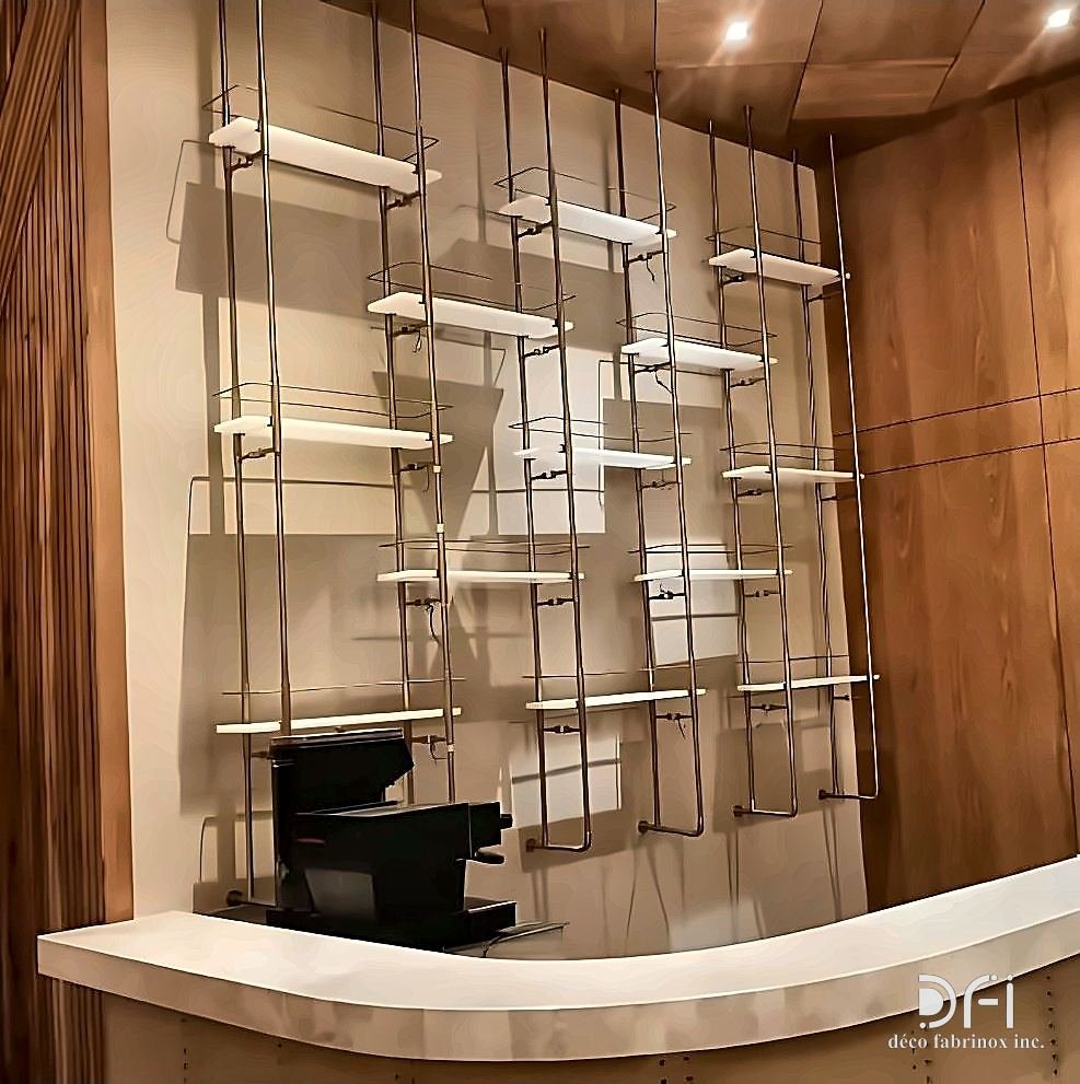 Slender brass display shelving against a marble wall