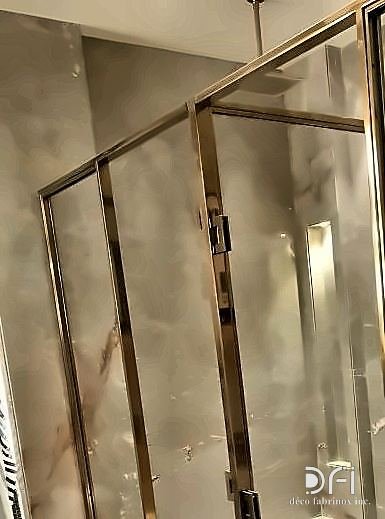 Brass-framed glass partition in a hotel bathroom