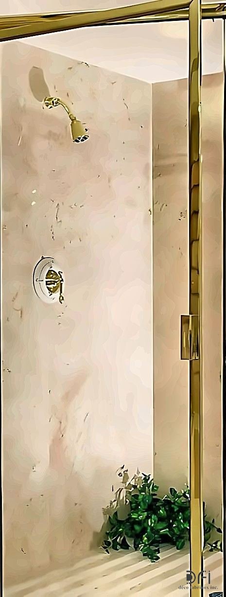 Brass-framed shower enclosure in a marble bathroom