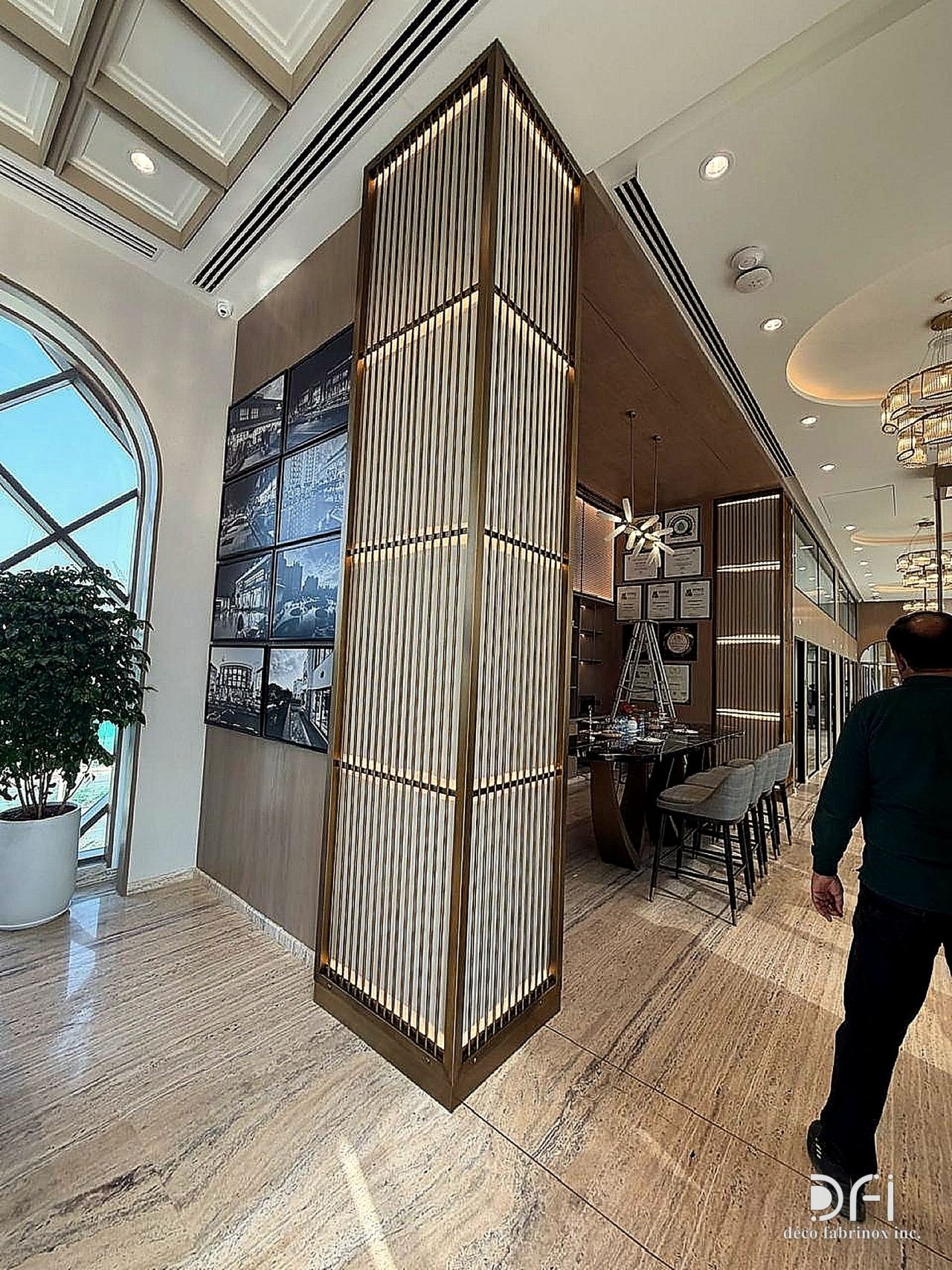 Brass-framed slatted metal column feature in an office