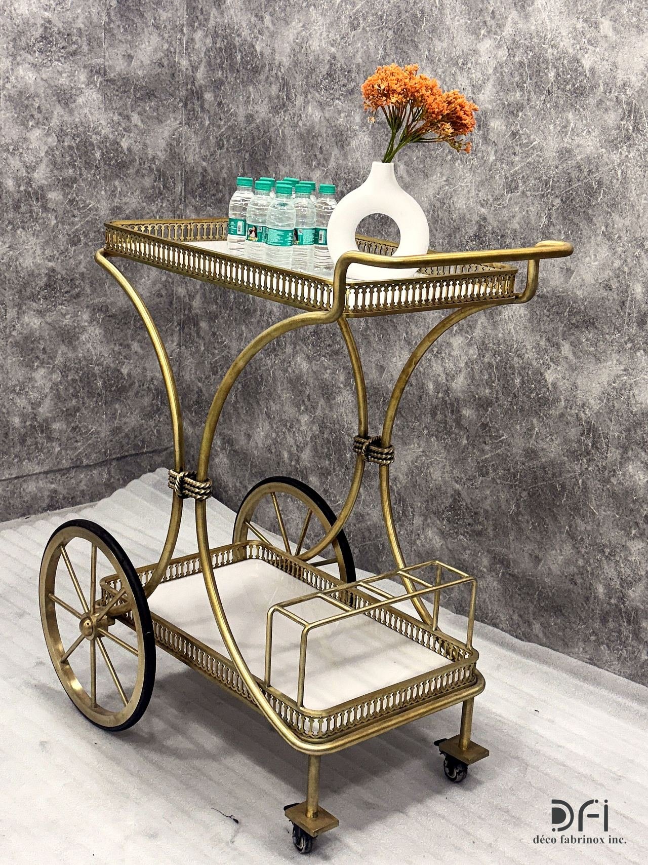 Brass hotel serving trolley with spoked wheels and a marble shelf