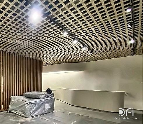 Brass open-cell ceiling grid over a reception area
