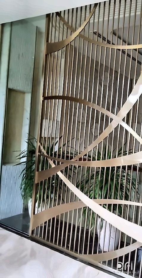 Brass ribbon screen across a staircase void