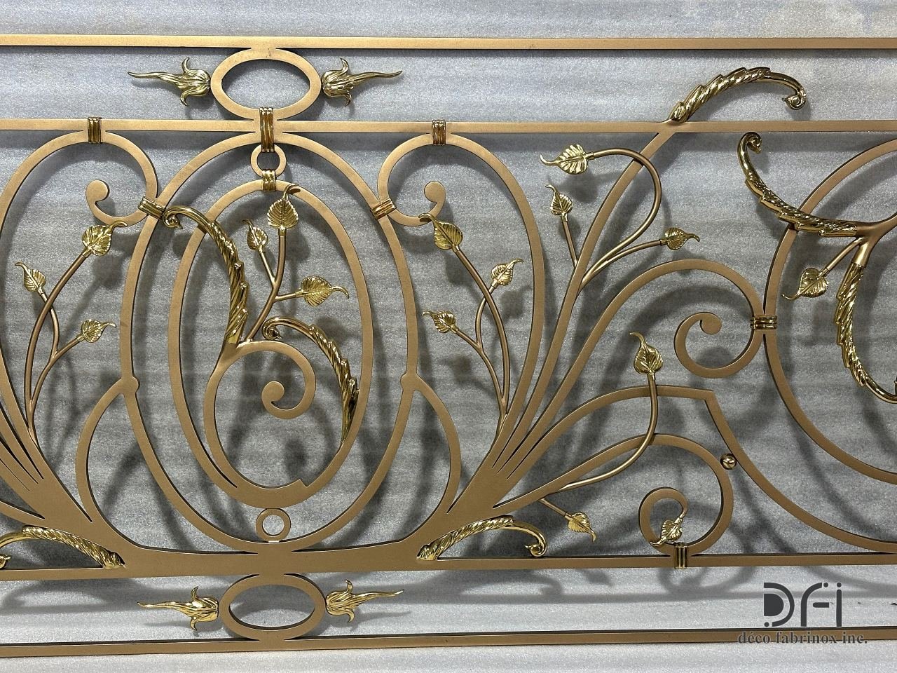 Bronze-finish scroll railing panel with gold leaf ornaments